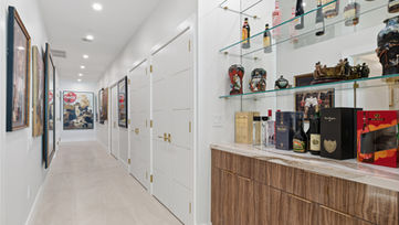 Modern condo hallway with built-in wet bar, glass shelving, and luxury finishes photographed by Edwin Figueroa Photography
