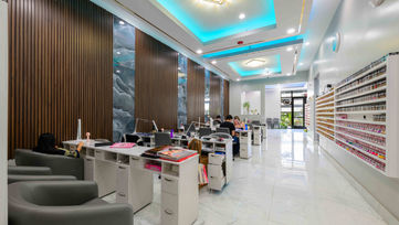 Long view of manicure stations and product wall inside Tipsy Nails & Bar West Palm Beach
