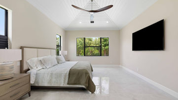 Bright primary bedroom with vaulted ceiling, modern ceiling fan, large window, and polished tile floors in a luxury home