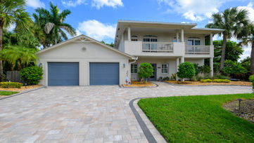 Exterior view of a two-story luxury home in Ft. Pierce, Florida with landscaped driveway