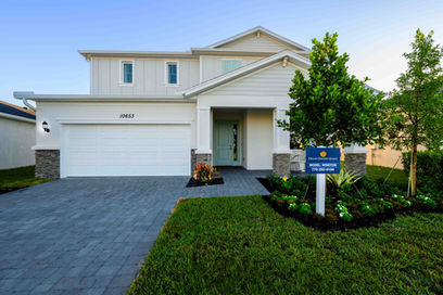Builder model home exterior with paved front yard in PSL