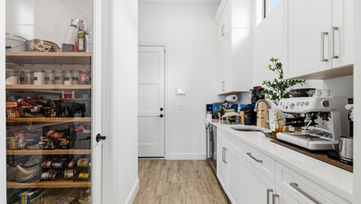 Pantry and kitchen prep area with storage shelves photographed in Port St. Lucie home interior
