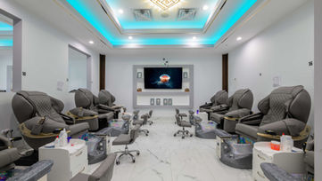 Wide view of pedicure lounge with multiple stations and ceiling accent lighting at Tipsy Nails & Bar