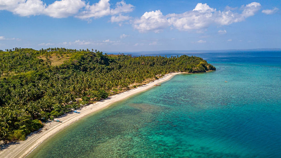 Aerial view of tropical island in the Philippines surrounded by crystal clear blue water and coral reefs