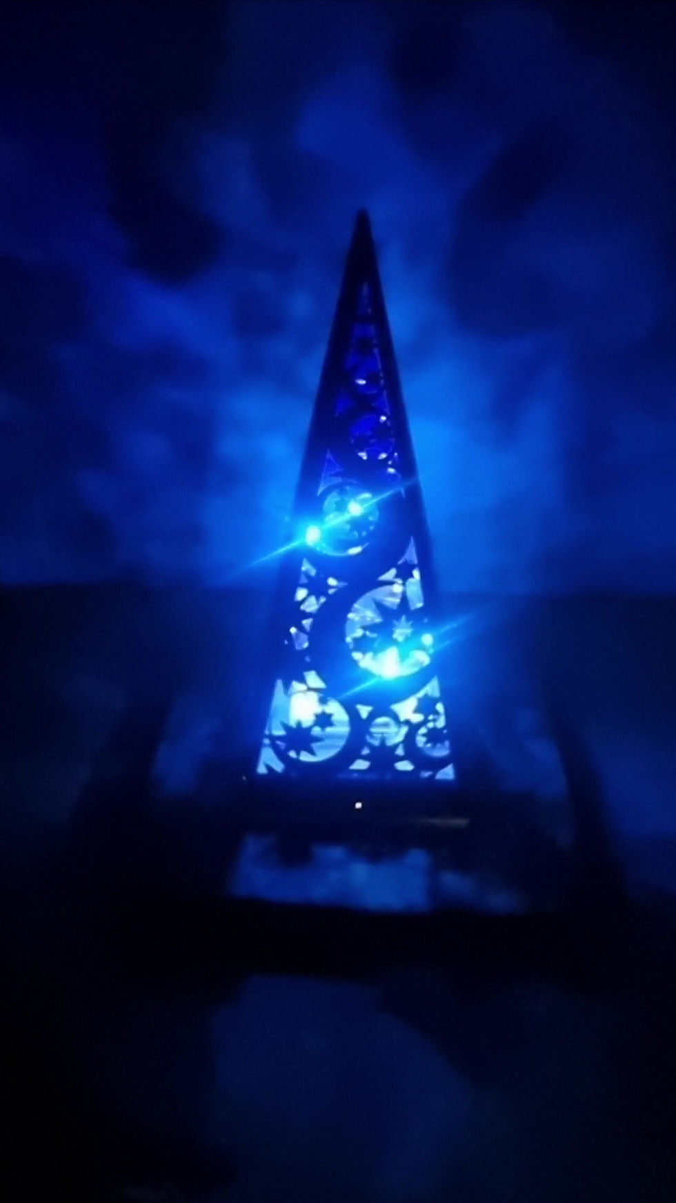 Thumbnail: Matt Black & Blue Acrylic Pyramid Lantern shining at night with crescent moon and star designs lighting up the wall