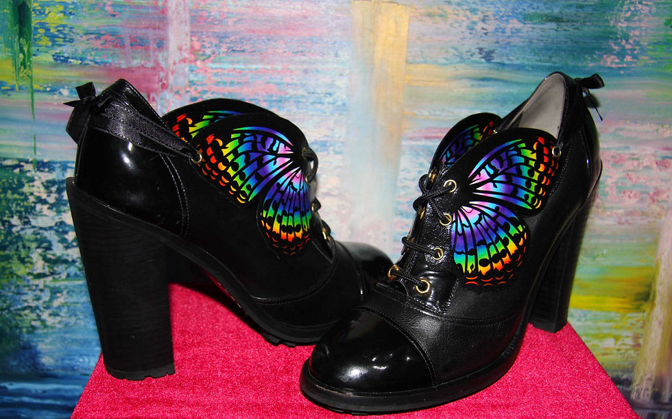 Thumbnail: Four Progress pride flag shoewings tied back on a pair of lace-up boots so they don't flap around