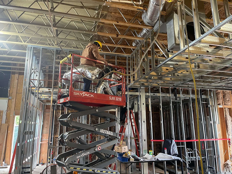 technicians installing ductwork in a commercial new construction