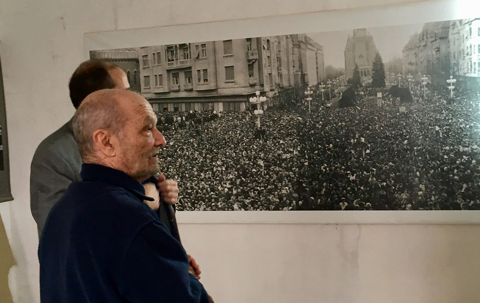 Dr Orban, wounded hero of 1989 Revolution, in front of photo; composer Aaron Garber in background