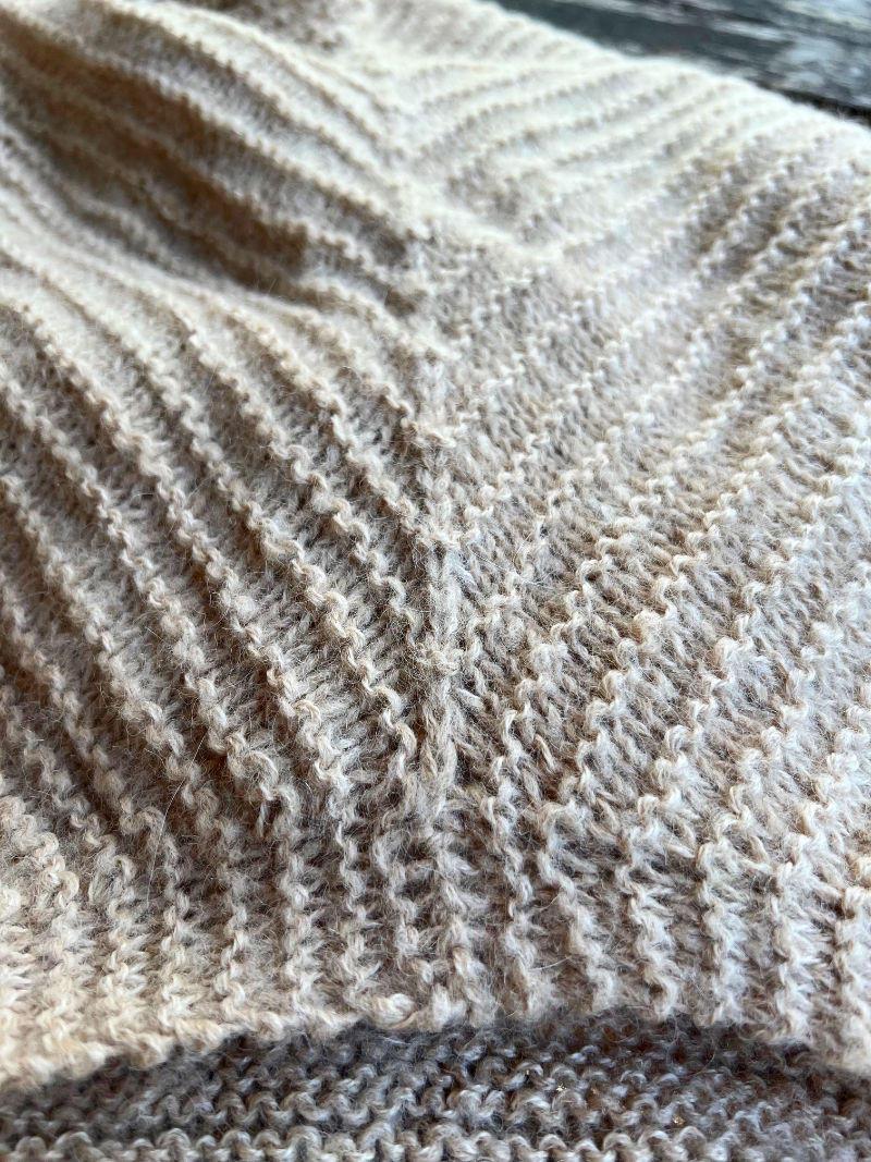 Wenn das Dreieck für das Vorderteil und das Rückenteil verbunden werden, wird die Seitennaht aus Abnahmen erstellt. Sie ergibt nicht nur optisch eine Seitenlinie, sondern sorgt dafür, dass das Strickstück stabil bleibt und sich nicht in die Länge zieht.