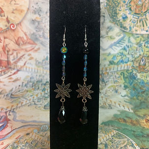 Closeup of a pair of earring with black irridescent beads and metallic black stars