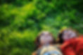 Two children laying on their backs in the yard, looking up happily into the sky.