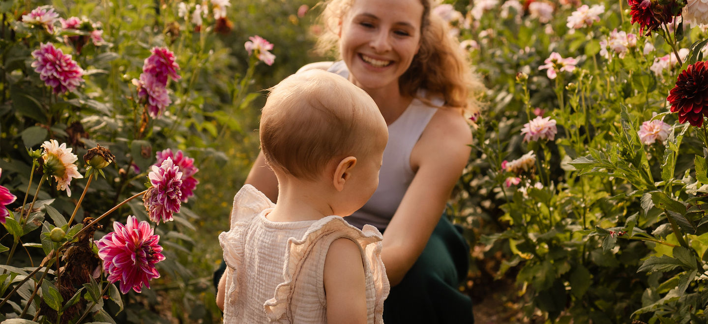 Mutter mit Kleinkind bei Familienshooting im Blumenfeld