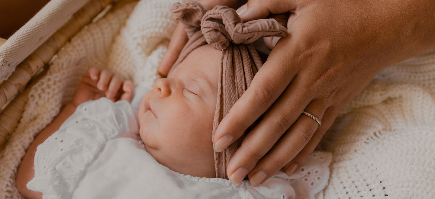 Mamas Hände halten Babykopf Newbornshooting Homestory