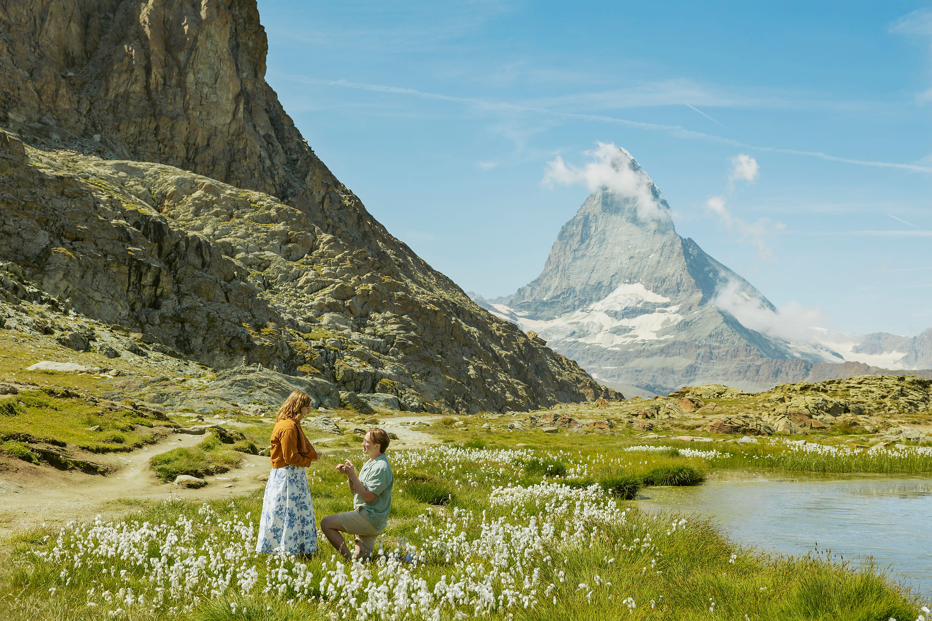 A surprise wedding proposal at Stellisee in Zermatt, Switzerland, with the Matterhorn reflecting in the lake. The bride-to-be, radiant with perfect white nails, celebrates with her fiancé during a magical couple photography session.