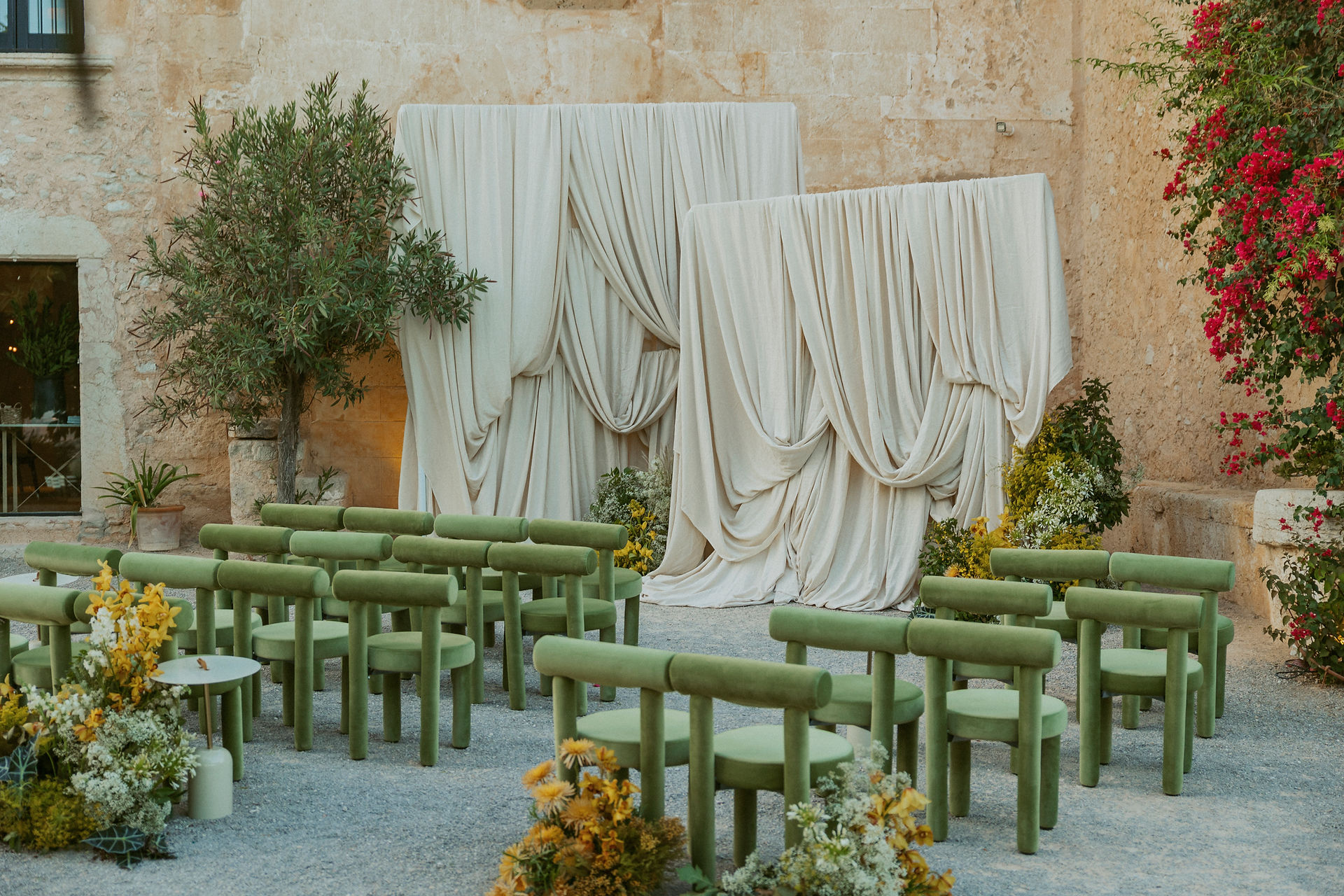 Wedding ceremony set up in front of a rustic stone building at The Lodge, Mallorca, Spain, with olive trees and Mediterranean views.