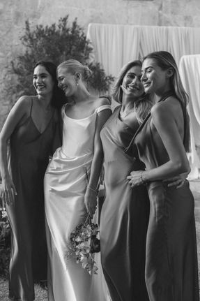 Mediterranean wedding at The Lodge Mallorca, bride and bridesmaids laughing together, candid bridal party moment