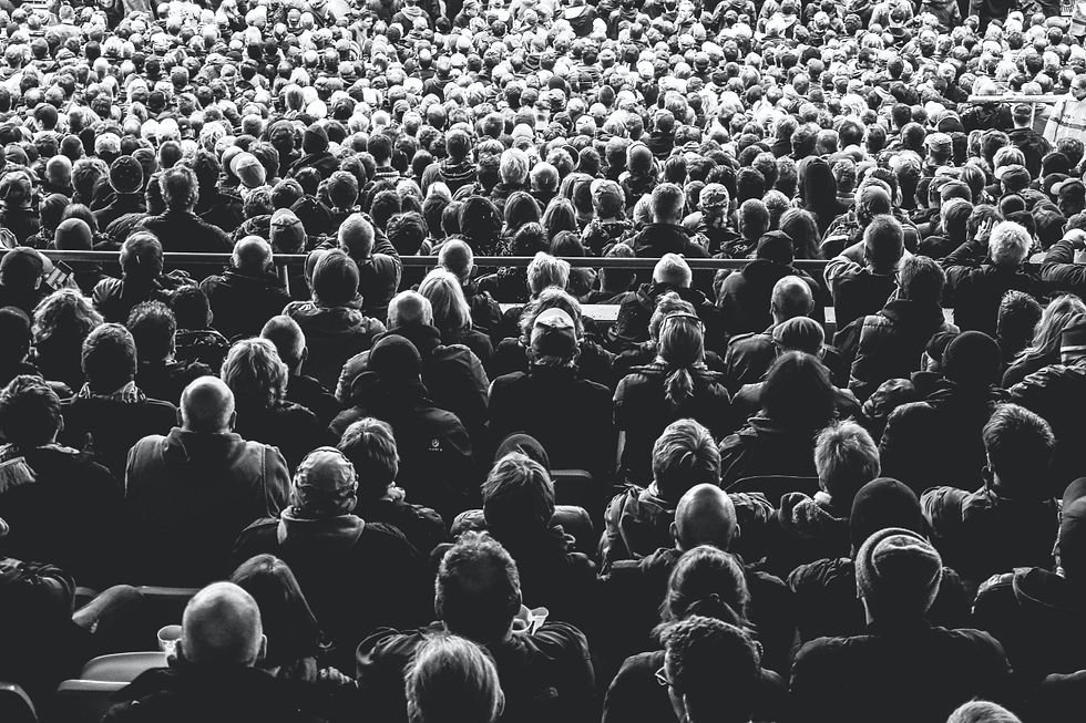 Black and white image of a crowd facing a stage