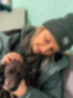Frau mit Mütze streichelt einen Hund vor Ort in Bosnien