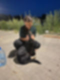 Frau kuschelt mit schwarzem Hund vor Ort in Bosnien.