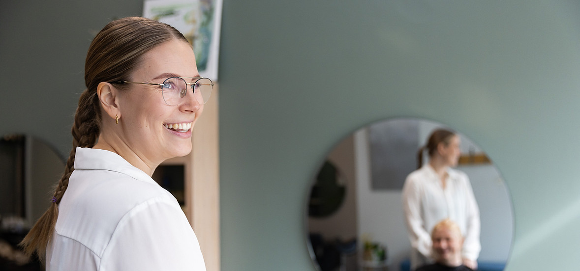 Kuvassa kampaajayrittäjä hymyilee