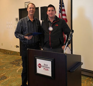 At the Rotary Club of Newport meeting, Jeff Peterson(left) receives his "Blue Badge" from Greg Rodocker.