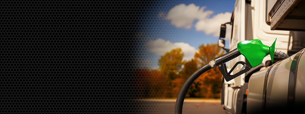 Green fuel nozzle filling a truck's tank with a beautiful autumn background.