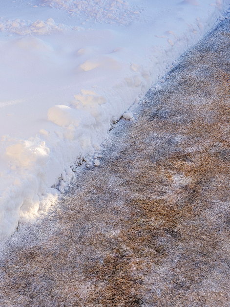 Fresh sand laid on top of a snow covered driveway