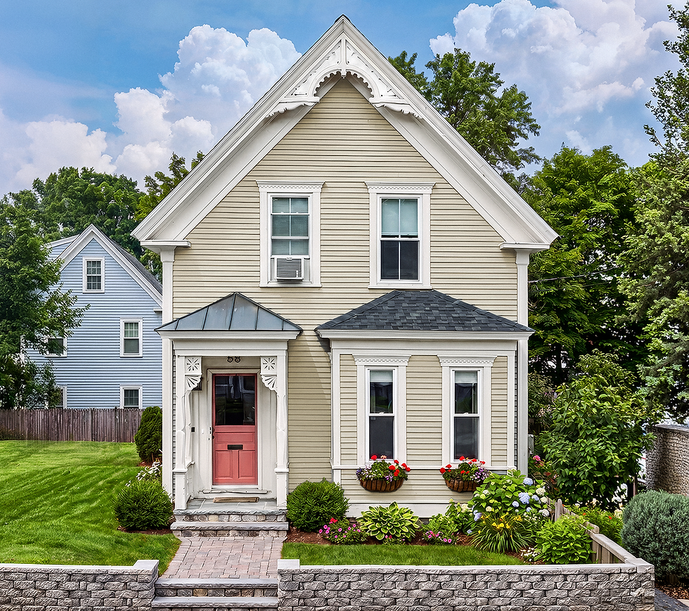 Small tan house with pink front door and flower boxes
