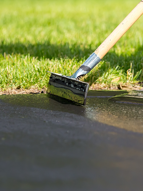 Squeegee applying driveway seal coating