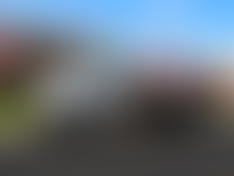 White heating and cooling truck on suburban street with pink blossoming trees and a brick house. Text: "Reinhardt Home Heating & Cooling."