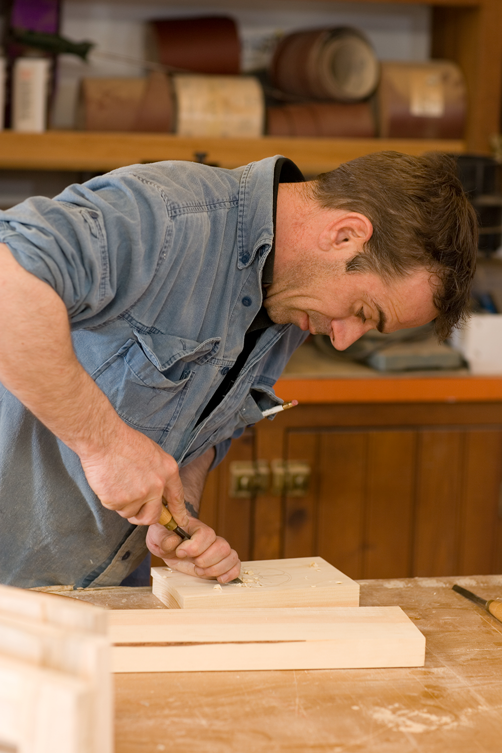 Craftsman carefully carving wood in workshop