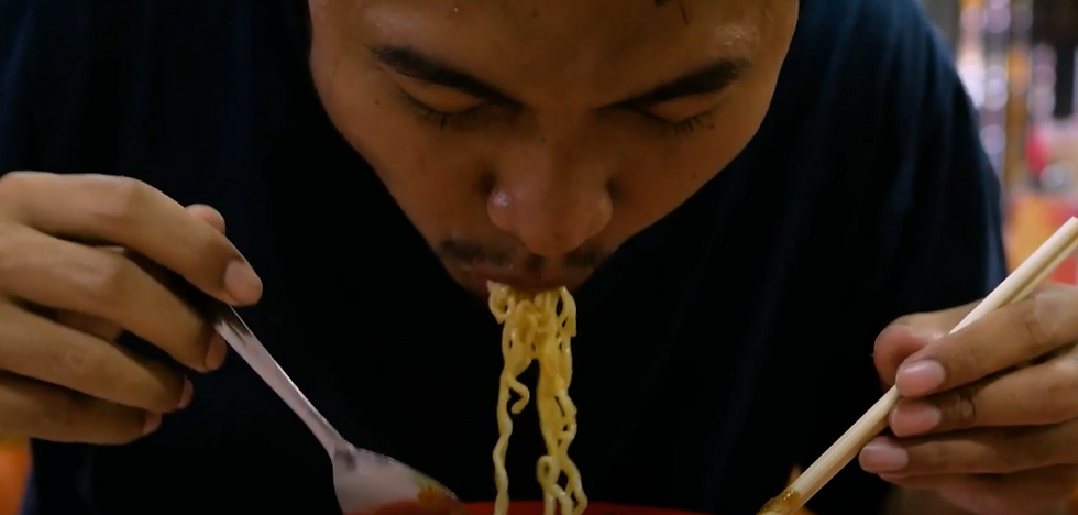 un homme qui mange des nouilles