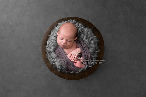 newborn-baby-boy-wrapped-in-bowl-blue-ri