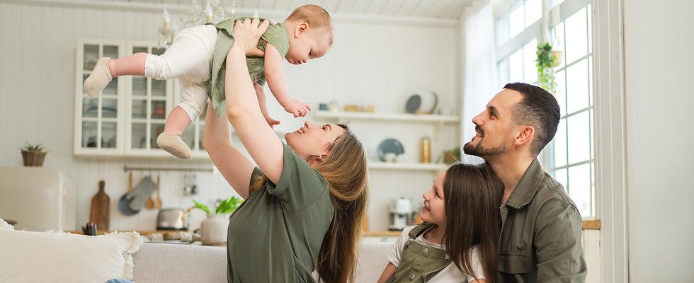 Happy family at home. Mother father two children daughters relaxing on sofa indoor. Mom da