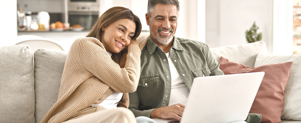 Happy middle aged couple using laptop re