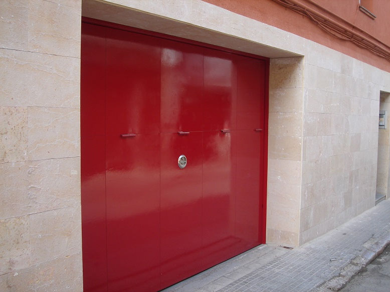 Porta basculant metàl·lica amb estructura d'acer d'alta resistència, folrada amb xapa metàl·lica galvanitzada per a més protecció davant la corrosió i les condicions climàtiques. Sistema dʻobertura basculant segur i durador, ideal per a garatges i accessos exteriors. Acabada de color vermell, pintada pel client, aporta un estil divertit i personal sense comprometre la funcionalitat, el baix manteniment i la llarga vida útil de la porta.