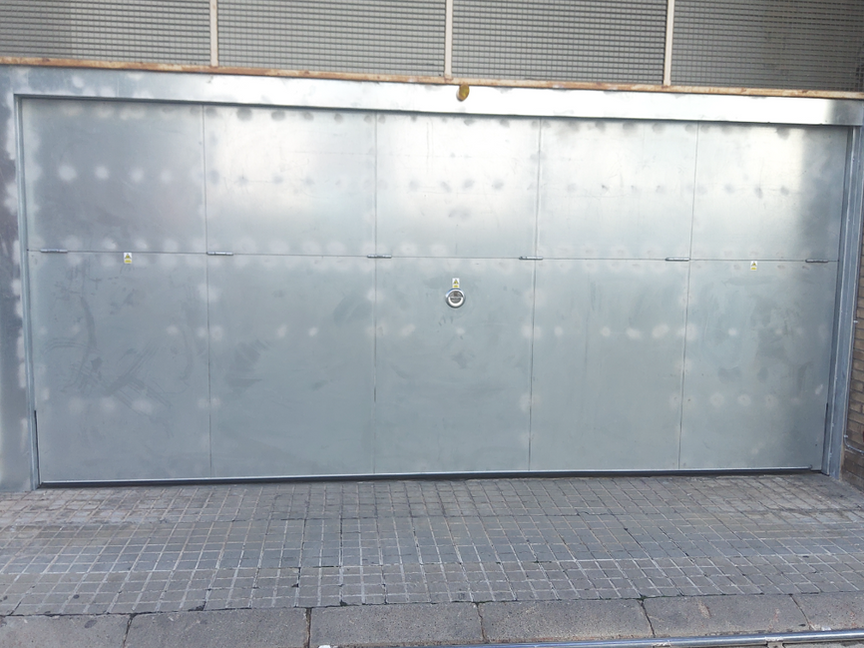 Porta basculant metàl·lica amb estructura d'acer reforçat i folrada amb xapa metàl·lica galvanitzada, ideal per a ús comunitari i accessos d'alt trànsit. Sistema d'obertura basculant robust i segur dissenyat per a garatges comunitaris, edificis residencials i zones comunes. Ofereix alta resistència a la corrosió, gran durabilitat, baix manteniment i un funcionament fiable fins i tot en usos intensius.