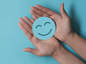 Hand holding paper cut smile face, positive thinking, mental health assessment , world men