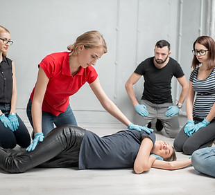 Young woman instructor showing how to lay down a woman during the first medical aid traini
