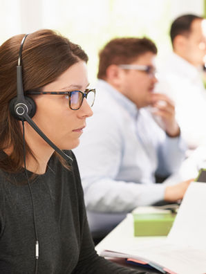 A woman with a headset on, in a call centre