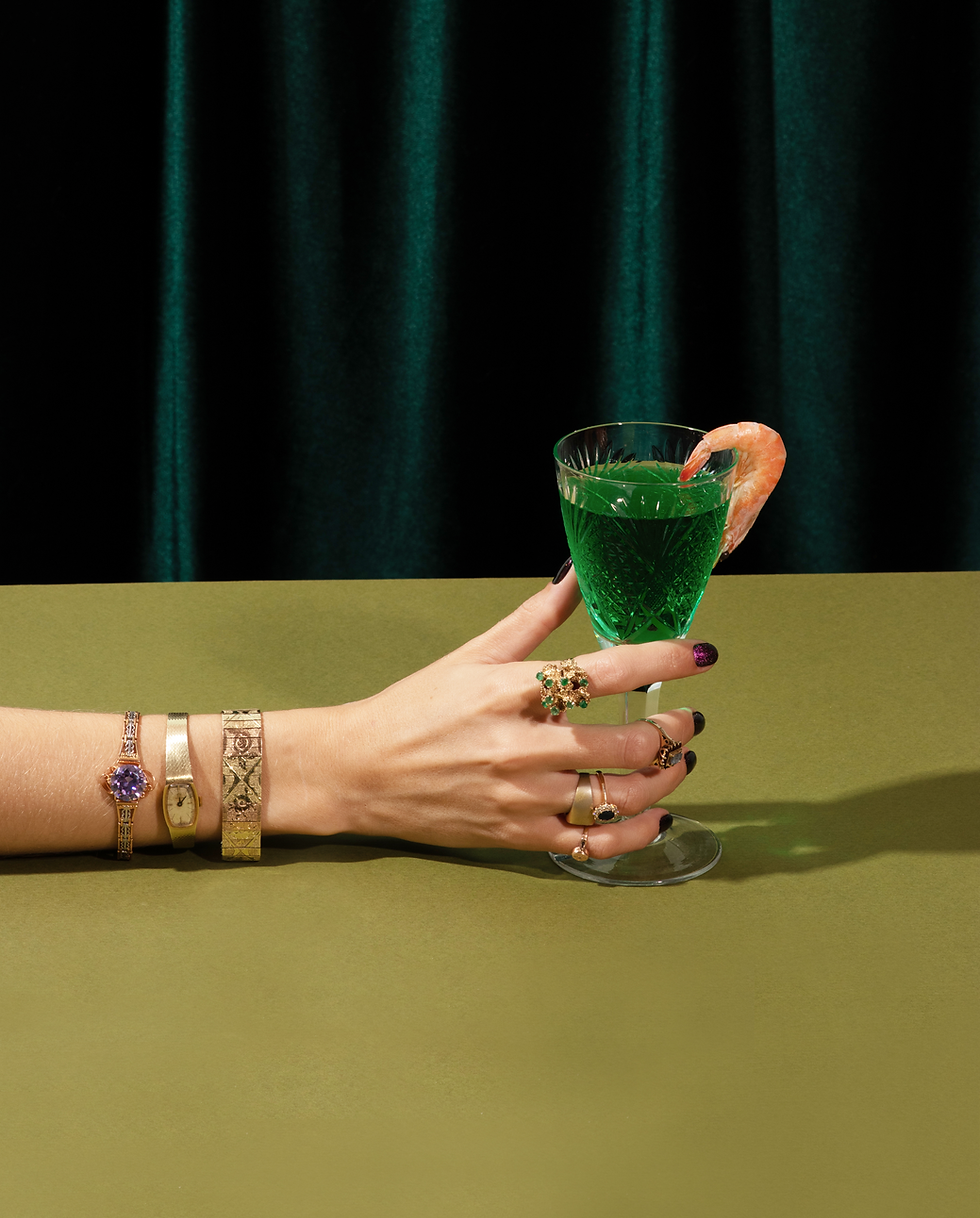 Women hand adorned with jewelry holding a cocktail