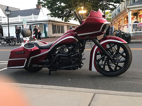 Custom red Harley Davidson motorcycle parked on street