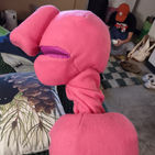 The image is of the profile of a pink puppet with a giant, elephant like nose. It is facing left.