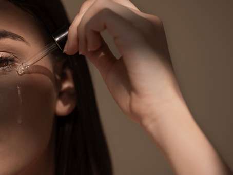 Woman applying hydrating serum to cheek to repair skin barrier