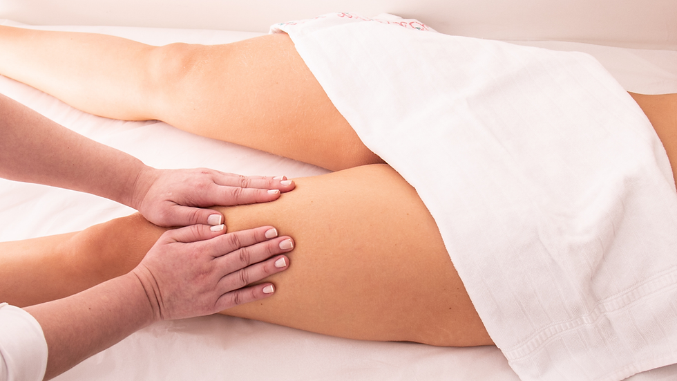 Therapist performing lymphatic drainage massage on client’s legs in Surrey
