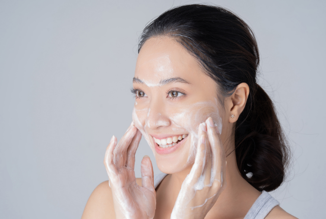 Woman massaging facial cleanser into skin to remove makeup and impurities