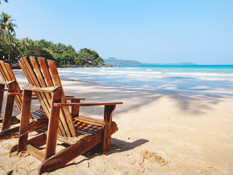 Sunbed on beach by the ocean representing relaxing summer holiday