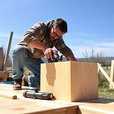 Man sanding a wooden box outdoors