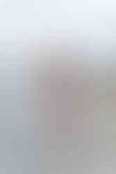 maternity photo by water of mama looking behind shoulder