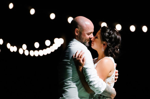 Bride and Groom dancing under string lights - wedding festoon lighting sets the mood